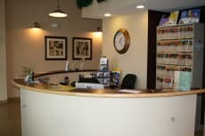 The clinic's curved front desk, with a wall clock above it